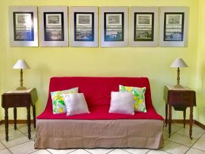 een rode bank in een kamer met foto's aan de muur bij Elegante Wohnung in der grünen Umgebung des Parks einer venezianischen Villa in Mira