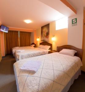 Habitación de hotel con 3 camas y TV en CESAR'S HOTEL PERU, en Puno