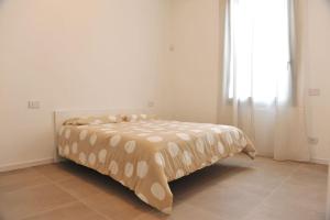 Cama en habitación blanca con ventana grande en Appartamento Bartolomeo Colleoni, en Cavernago