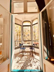 Habitación con mesa, sillas y ventanas. en Mediterranean Hostel Barcelona, en Barcelona