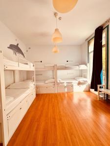 a room with three bunk beds and a wooden floor at Mediterranean Hostel Barcelona in Barcelona