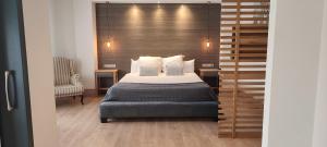 a bedroom with a bed and a wooden wall at Hotel Sercotel Cuatro Postes in Ávila