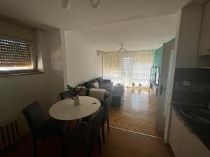 een woonkamer met een tafel en een bank bij Stan na dan in Šid