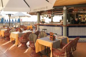 een restaurant met tafels en stoelen met geel tafelkleed bij Stunning Views Guaranteed in Taurito