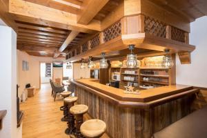 eine Bar in einem Restaurant mit Holzwänden und -hockern in der Unterkunft Wohnung in Reith Im Alpbachtal mit Garten und Terrasse in Reith im Alpbachtal