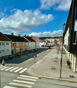 an empty street in a town with buildings and a crosswalk at Sentralt og romslig i Kristiansand sentrum in Kristiansand