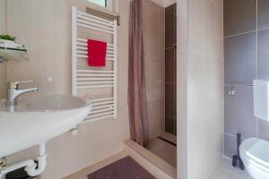 uma casa de banho com um lavatório e um chuveiro em A104 Apartman em Siófok