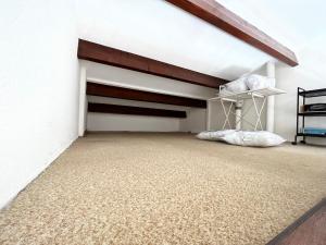 1 dormitorio con 1 cama elevada en una pared blanca en Villa T3 6 couchages - Piscine-WIFI-Garage en Saint-Cyprien
