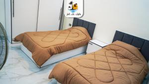 - 2 lits avec des couvertures brunes dans une chambre dans l'établissement The palm heaven chalets, à Jerash
