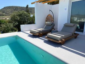 2 sillas sentadas junto a una piscina en Kostantakis Residence & Winery en Pollonia