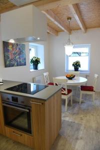 eine Küche und ein Esszimmer mit einem Tisch und einem Herd in der Unterkunft Kleines Ferienhaus in Umkirch - b57430 in Umkirch