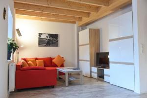 uma sala de estar com um sofá vermelho e uma televisão em Kleines Ferienhaus in Umkirch - b57430 em Umkirch