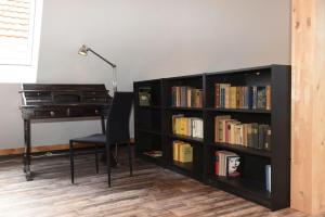 ein schwarzes Bücherregal mit einem Schreibtisch und einer Lampe in der Unterkunft Kleines Ferienhaus in Umkirch - b57430 in Umkirch