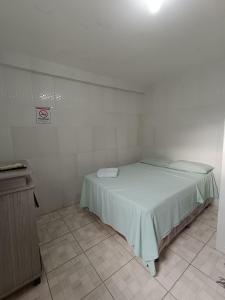 a small white room with a bed in it at Pousada Santo Amaro in Juazeiro do Norte