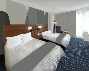 a hotel room with two beds and a chair at Welcome Parkhotel Bochum in Bochum