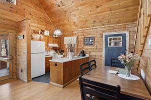une cuisine et une salle à manger avec une table et un réfrigérateur dans l'établissement Cozy family friendly Cabin with hot tub, near Gatlinburg, Pigeon Forge, Dollywood, à Sevierville