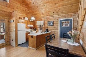 a kitchen and dining room with a table and a refrigerator at Updated family friendly Cabin, hot tub, near Gatlinburg, Pigeon Forge, Dollywood in Sevierville