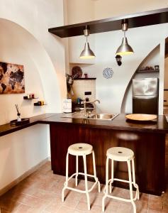 una cucina con due sgabelli e un bancone con lavandino di Casa dell Artista Tameró HolyDay Apartments a Montopoli in Sabina