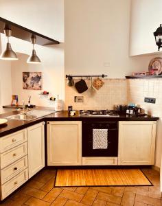 una cucina con piano cottura nero e forno di Casa dell Artista Tameró HolyDay Apartments a Montopoli in Sabina