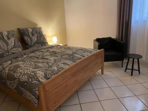 a bedroom with a large bed and a chair at Guest House Ida in Cetara