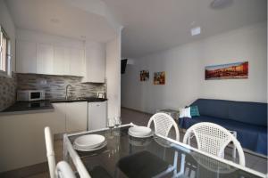 a kitchen and a living room with a table and chairs at Michelangelo Resort Apartments in San Miguel de Abona