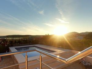 - un balcon offrant une vue sur le coucher du soleil dans l'établissement wundeschönes Ferienhaus mit eigenem Pool und Meerblick, à Bilice