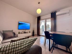 - un salon avec un canapé et une table dans l'établissement White Coast Apartment, à Saranda