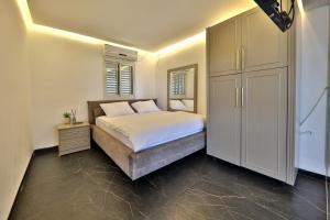 a bedroom with a bed and a large cabinet at שקיעה בים - דירות נופש יוקרתיות עם ג'קוזי ונוף לים in Haifa