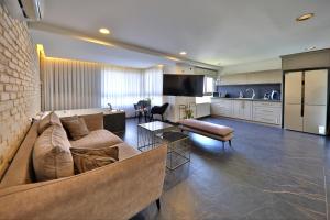 a living room with a couch and a kitchen at שקיעה בים - דירות נופש יוקרתיות עם ג'קוזי ונוף לים in Haifa