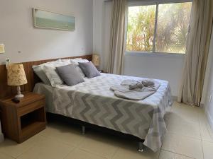 een slaapkamer met een bed met handdoeken erop bij Pipa Paradise, Central, Praia do amor in Pipa