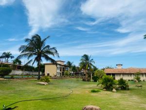 een tuin met een huis en palmbomen bij Pipa Paradise, Central, Praia do amor in Pipa