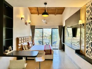 a hotel room with a bed and a table at Wanna Stay Bhimtal in Bhīm Tāl