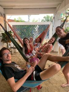 Taida Hostel Rincon del Mar في Rincón: مجموعة من الناس يجلسون على أرجوحة