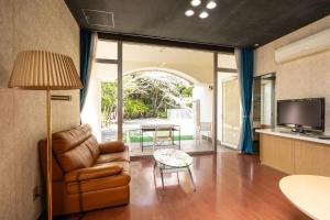 a living room with a couch and a table at Higashi Kumamoto Business Center in Ozu