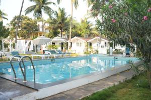 a pool at a resort with palm trees at Seawood Beachfront Resort in Morjim