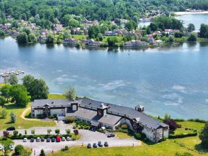 an aerial view of a large house on a lake at Hôtel du Golf de l'Ailette, The Originals Relais in Chamouille