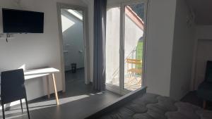 a room with a window and a desk and a television at La casa al mare di MatiGiò in Pietra Ligure