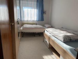 two beds in a room with a window at Wiesenblick in Radolfzell am Bodensee