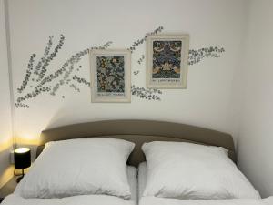 uma cama com duas almofadas e duas fotografias na parede em FeWo Glockenberg im Ferienpark Altenau em Altenau
