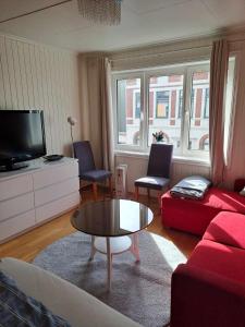 a living room with a red couch and a coffee table at Apartment Bystranda - City Beach in Kristiansand