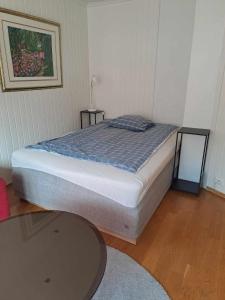 um quarto com uma cama e uma mesa num quarto em Apartment Bystranda - City Beach em Kristiansand