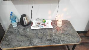 a marble table with a candle and a bottle of water at Lions BNB in Indore
