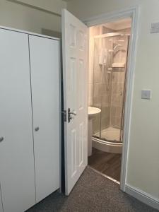 a bathroom with a shower and a white door at Studio Flat 7 With Private Shower & WC in Nottingham