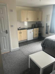 a kitchen with a bed and a table in a room at Studio Flat 7 With Private Shower & WC in Nottingham