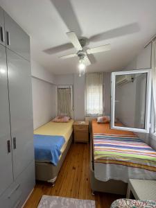 a bedroom with two beds and a ceiling fan at Villa 19 Apart Otel in Ilıca