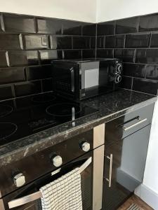 a kitchen with a counter with a microwave and a stove at Cadwgan House in Rhayader