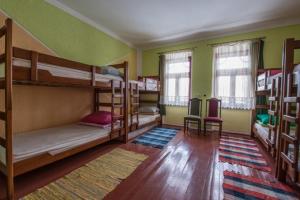 Habitación con 3 literas y alfombra. en CycloCamp & Hostel, en Skorenovac