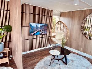 a living room with a chair and a tv at Amsterdam Boathouse in Aalsmeer