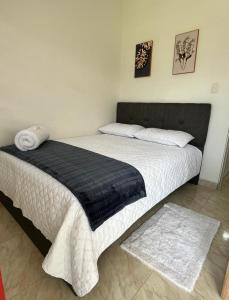 ein Schlafzimmer mit einem Bett mit einer schwarzen und weißen Decke in der Unterkunft CASA BONITA SALENTO - Suite para parejas o Alojamiento en Grupos in Salento