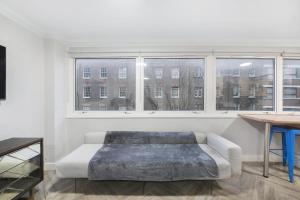 ein weißes Zimmer mit einem Bett und einem Fenster in der Unterkunft Luxury STUDIO APART’ COVENT GARDEN FITZROVIA W1 in London